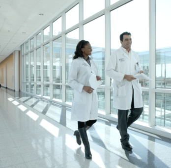 Students with white coat walking down the hall
                  