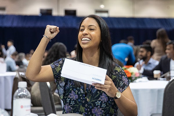 Student cheering after looking at her match envelope