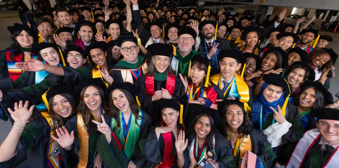 Students gather for an informal class photo in caps and gowns
